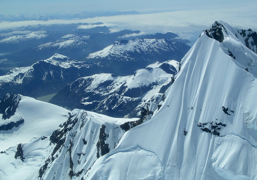 Peak of Mt. Crillon, Fairweather Range, Glacier Bay National Park, Alaska. Late June, early July. 2004. Note the two crevasse lines. Peak height&mdash;12, 726 feet/3,879 meters. A week later, these two crevasse lines collapsed. Alaska Airlines pilots flying over saw such clouds from the collapse they initially reported it as a volcano. Photograph by Abigail B. Calkin, 2004.