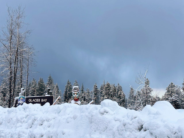 Welcoming sign and totem at totem at entrance to Glacier Bay National Park. Welcoming sign and totem at totem at entrance to Glacier Bay National Park. No wonder it’s closed in the winter. It now has a one-lane road too and winter workers have trouble getting to work. Even those with masters or PhDs in biology, geology, or whatever are have been on snow shovel duty.